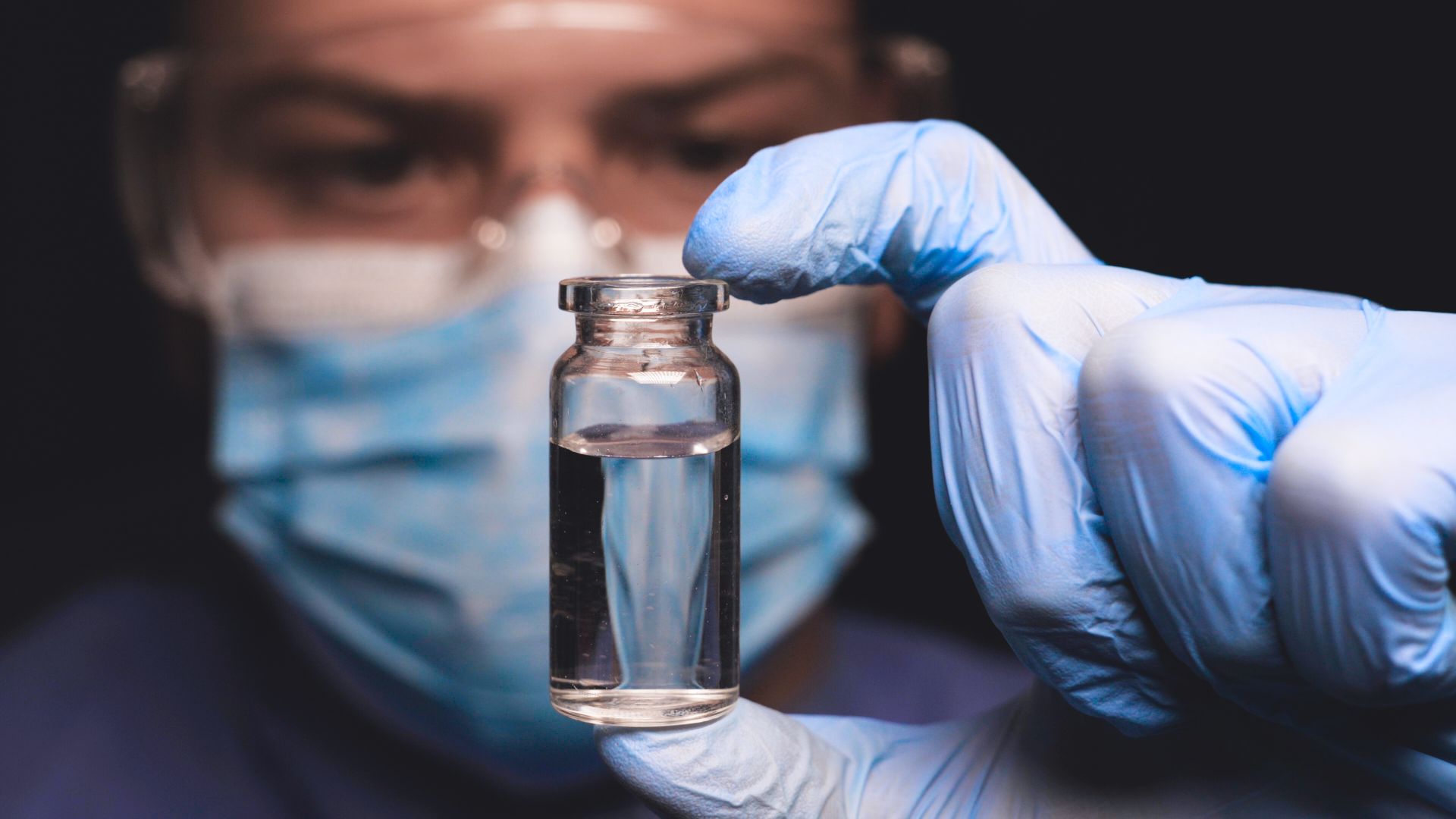 Man holding a container with clear liquid
